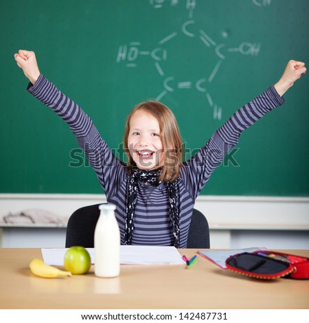 Happy student raising her hand inside the classroom