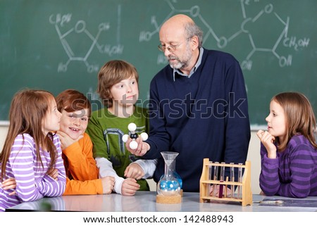 Portrait of teacher instructing students learning molecules