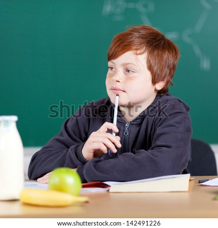 Young student thinking with pencil on his chin