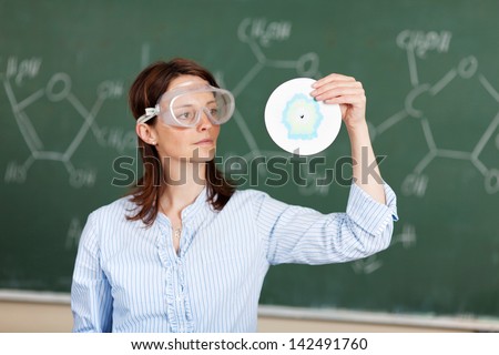 Instructor teaching about chemistry over the blackboard background