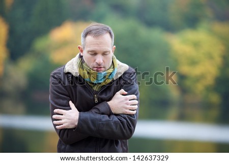 Mature man in jacket freezing from cold