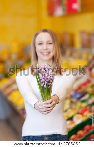 Portrait happy young woman holding flower bouquet in grocery store