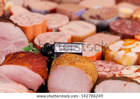 Closeup of meat and sign in refrigerated section of supermarket
