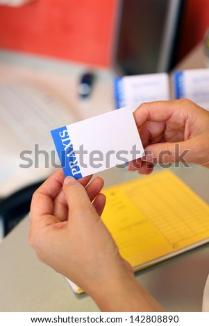 Closeup of dentist\'s hands holding blank note at counter