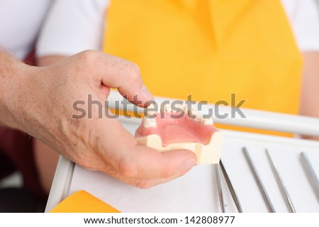 Dental surgeon molding prosthetic teeth in a close up shot
