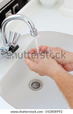 doctor washing hands in white basin in clinic