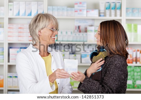 Pharmacist giving medication to a female in the pharmacy
