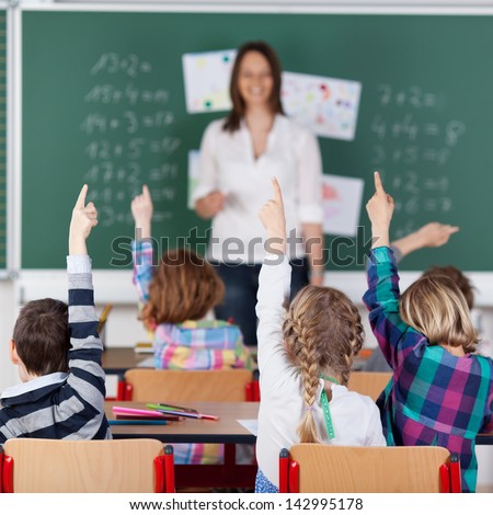 Portrait Of Children Raised Their Hands In The Classroom
