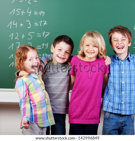 Portrait of laughing schoolchildren in front of panel