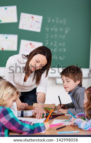 Portrait of teacher helping her pupils in art class