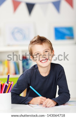 Happy young boy draw something on sketch pad