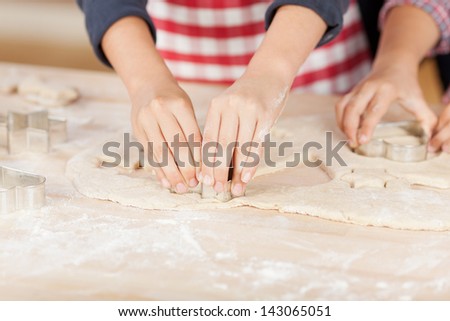Little hands decorating the gingerbread cookies for Christmas