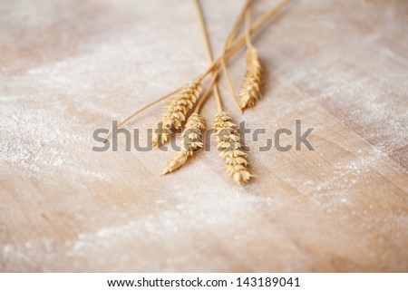 Few ears of grain on a wooden bakery table