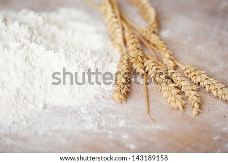 Heap Of Sieved Flour And Fresh Eras Of Golden Wheat Lying On A Bakery Table Depicting Ingredients Used In Baking Loaves Of Bread And Pastries