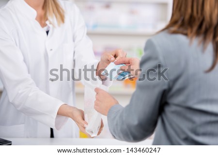 Patient pays for the medicine to the pharmacist with a twenty euro note while receiving the bag