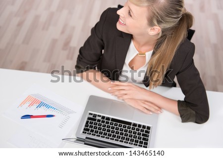 Businesswoman talking to someone while working using her laptop