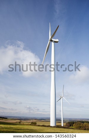 Wind turbine standing tall against the blue sky