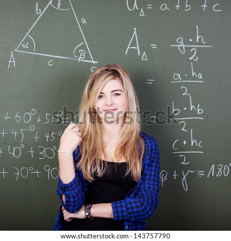 Smart student is standing in front of a blackboard