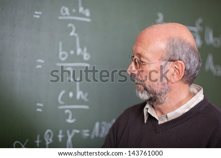 Portrait of teacher standing in front of a blackboard