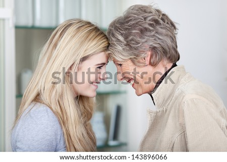 Side View Of A Happy Teenage Girl And Grandmother Looking At Each Other