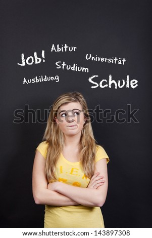 Confused teenage blond girl planning her future against black background