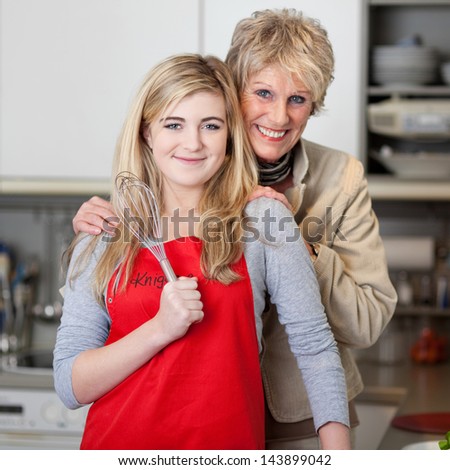 Portrait of a smiling grandmother and granddaughter in the kitchen