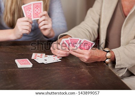 Photograph Of Two Females Playing Cards Together.