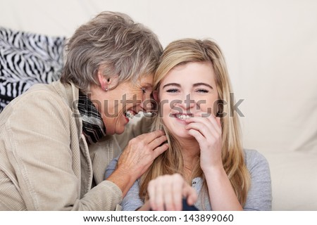 Photo Of Both Grandmother And Granddaughter Having A Funny Conversation And Giggling Together.