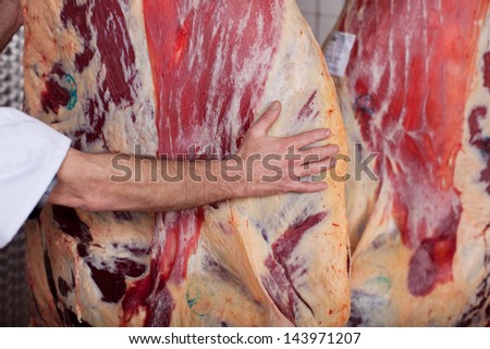 butcher with beef in a cold room