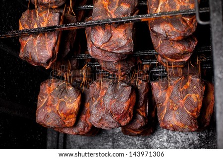 Ham hanging in the smoking house at butcher\'s shop