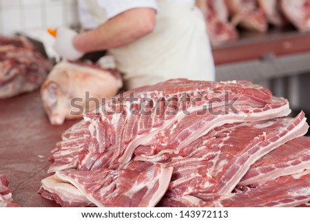 midsection view of a butcher cutting meat in cold room