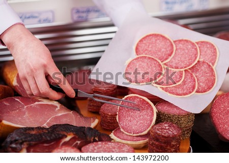 Closeup of butcher\'s hands packing meat in paper at shop