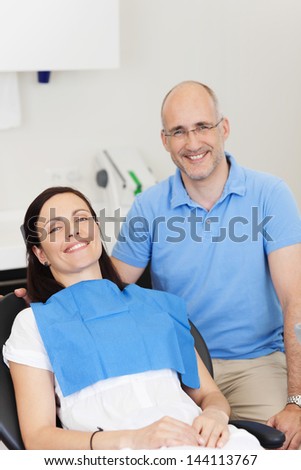 Portrait of dentist and patient smiling in clinic
