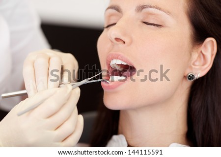 closeup of pretty female patient receiving treatment from dentist at clinic