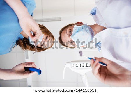 Directly below view of female dentists using dental tools in clinic