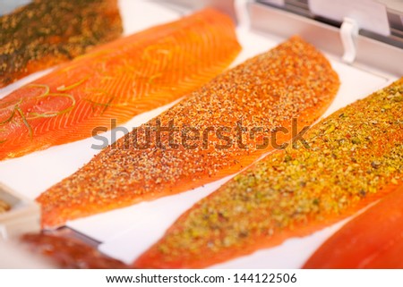 Variety of sliced fishes arranged in display cabinet at store