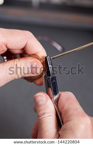 close-up of an optician repairing eyeglasses frame