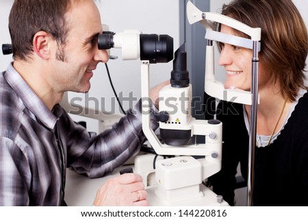 confident optician examine female patientÃ?Â??Ã?Â?Ã?Â´s eyes with measurement machine