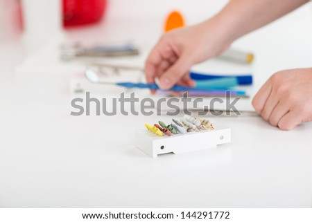 Closeup of dental technician\'s hands working at desk in workshop