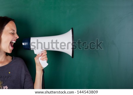Woman Screams Into Megaphone In Front Of A Blackboard