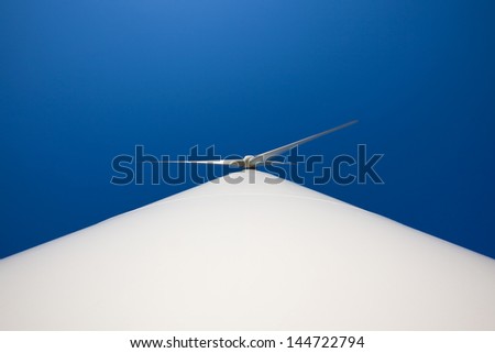 Odd angle of a wind turbine against blue sky
