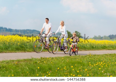 happy family riding bikes in green landscape