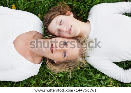 top view of mother and daughter lying head to head