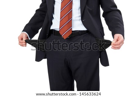 Man with empty pockets pulling them inside out to show his poverty isolated on white