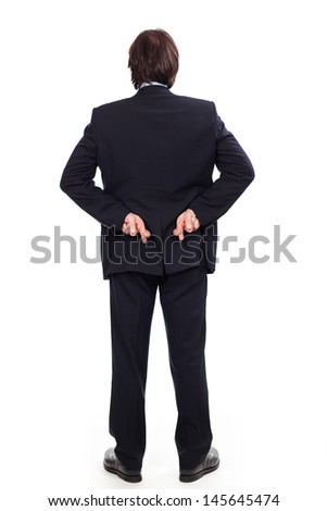 Businessman standing full length crossing his fingers behind his back as he embarks on a shady deal or in a gesture of hope isolated on white