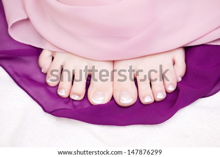 Overhead close up view of bare female feet with beautiful manicured toe nails after a pedicure treatment in a beauty salon