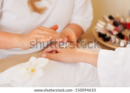 Beauty Therapist Doing A Manicure On The Hand Of A Young Woman In A Spa Or Salon, Closeup View Of Their Hands