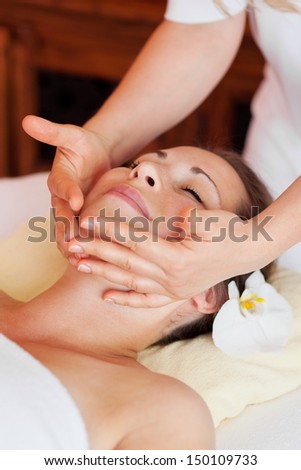 Young beautiful woman receiving a relaxing facial massage at a spa center Young beautiful woman receiving a relaxing facial massage at a spa center