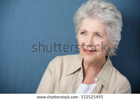 Beautiful senior woman daydreaming staring upwards with a gentle smile as she recalls nostalgic memories Beautiful senior woman daydreaming staring upwards with a gentle smile as she recalls nostalgic memories