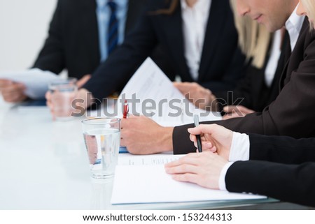 Close Up View Of The Hands Of Business People Taking Notes In A Meeting Seated At A Table